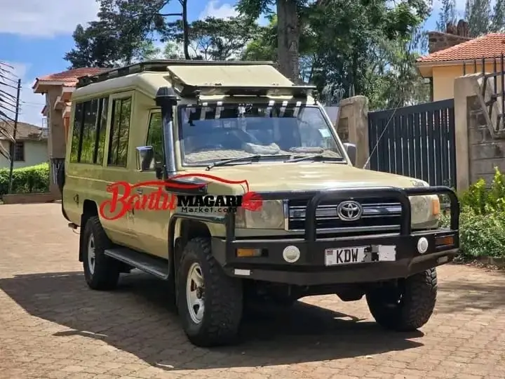 Classic beige and green Toyota safari Land Cruiser with bull bar and roof rack