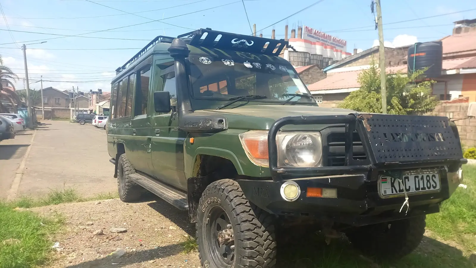 Green expedition-style Toyota Land Cruiser with roof rack and heavy-duty front protection