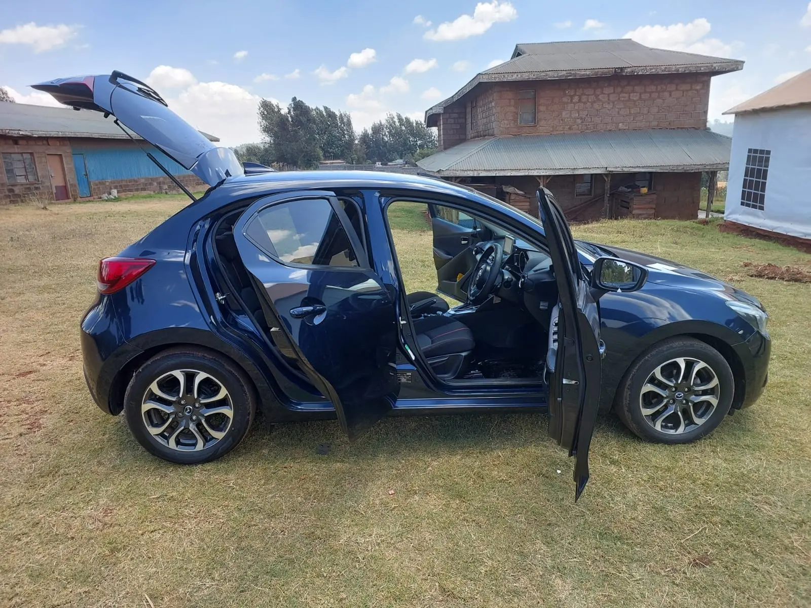 Dark blue Mazda Demio hatchback with doors open