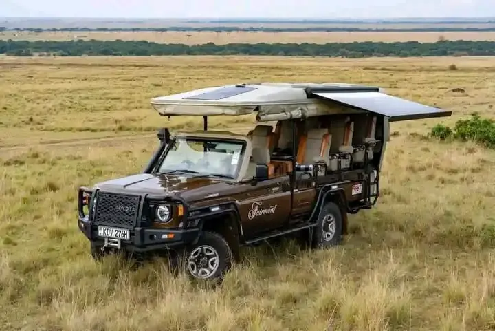 Dark open-roof safari Land Cruiser photographed on the savannah